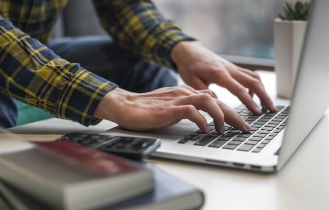 A man typing on a laptop.