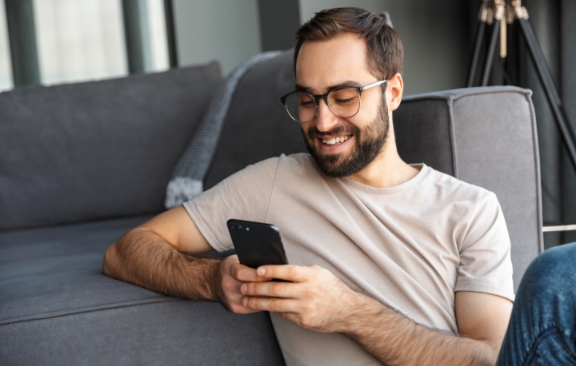 A happy man using his phone.