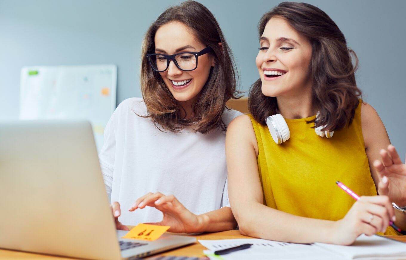 Two women working on a ShoutCMS website.