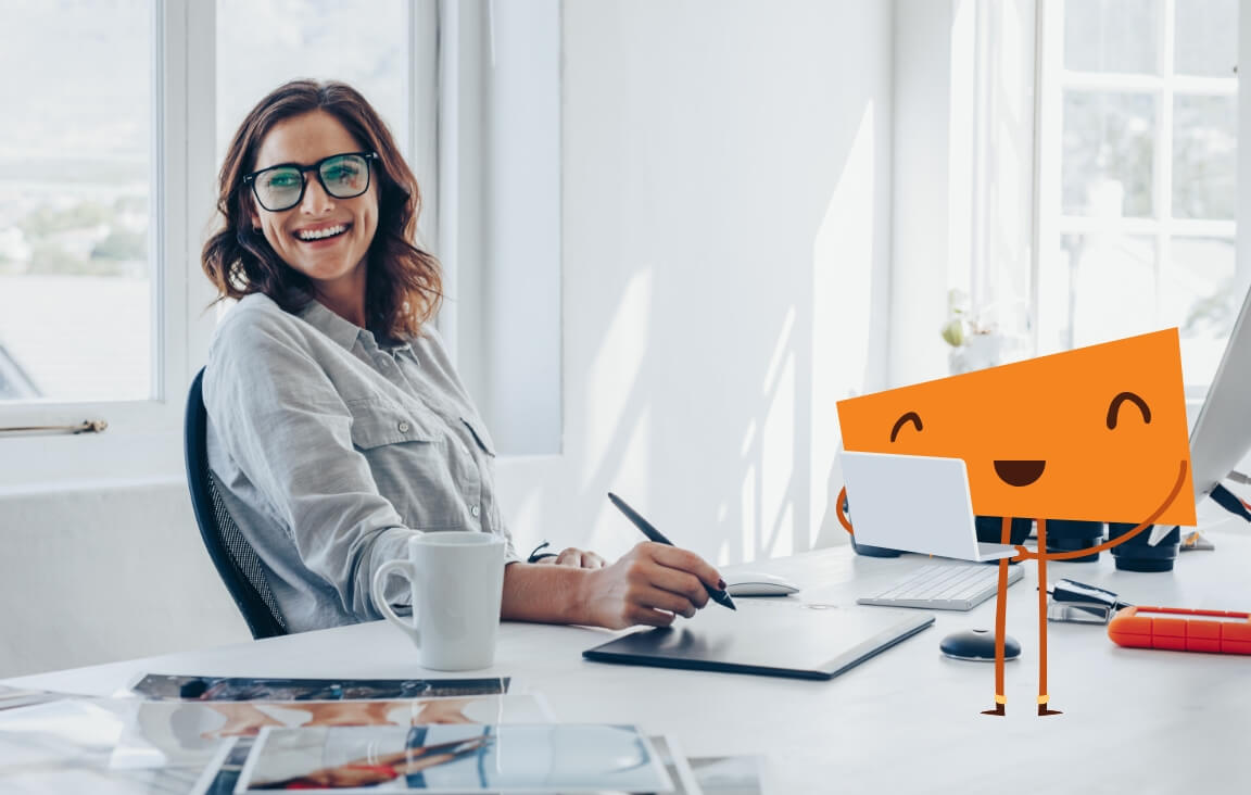 A woman smiling at her laptop.